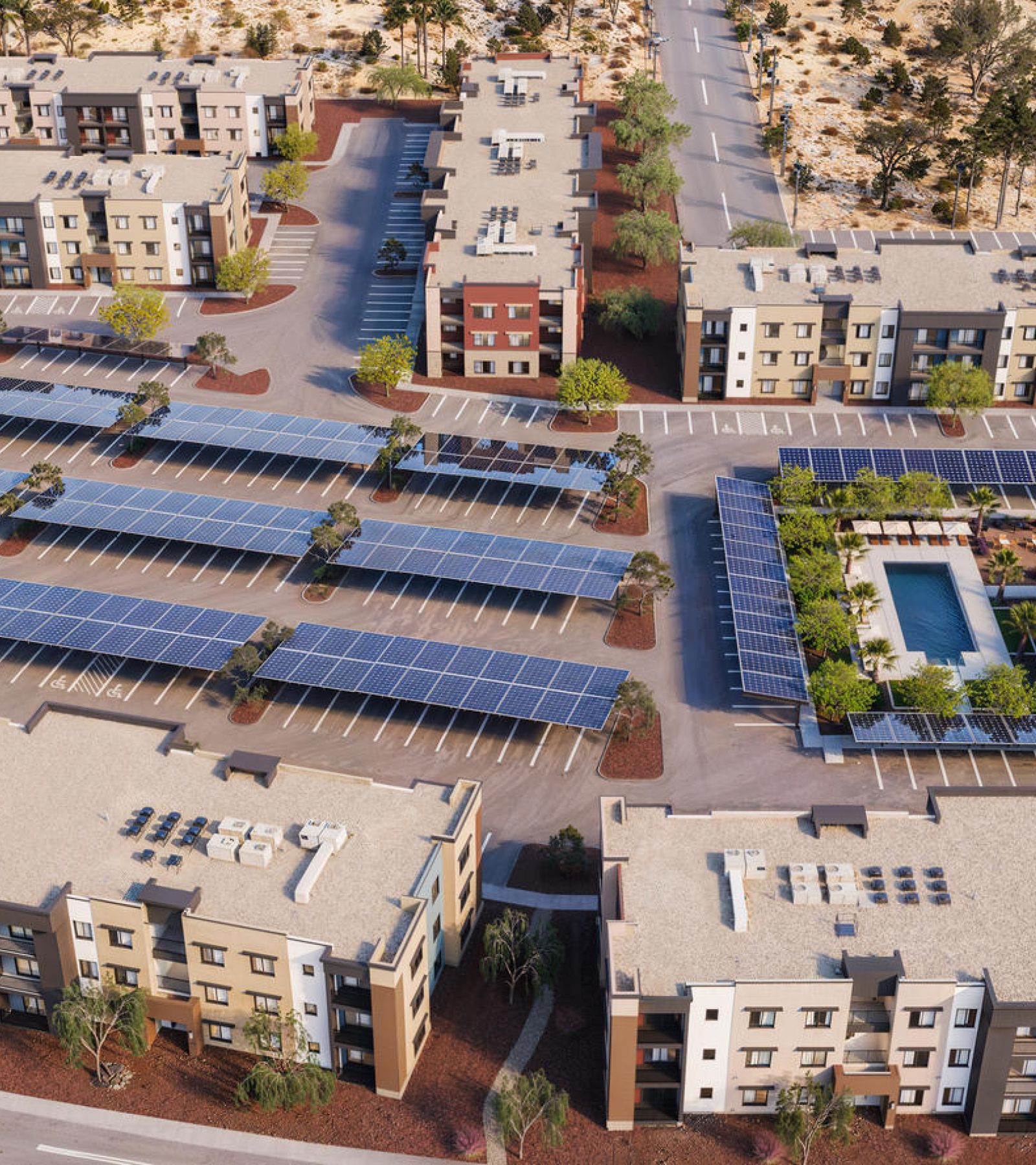 Aerial view of an apartment complex with solar panels, parking areas, and a central swimming pool.